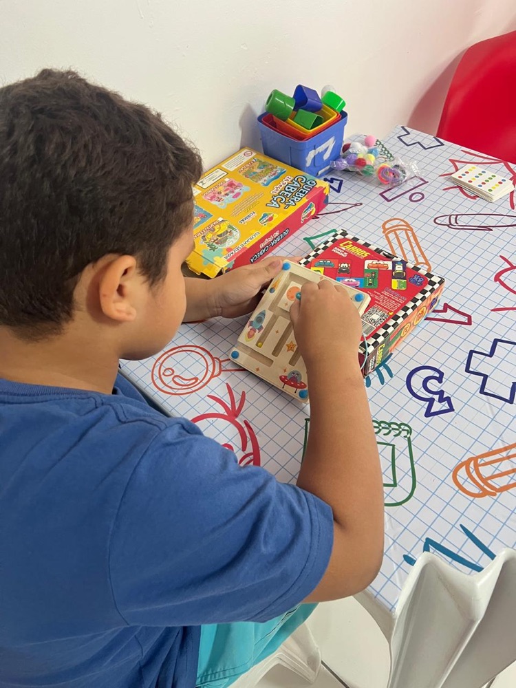 Criança explorando brinquedo pedagógico com o terapeuta